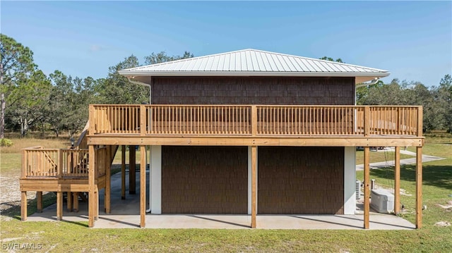 back of property featuring a yard, a deck, and a patio