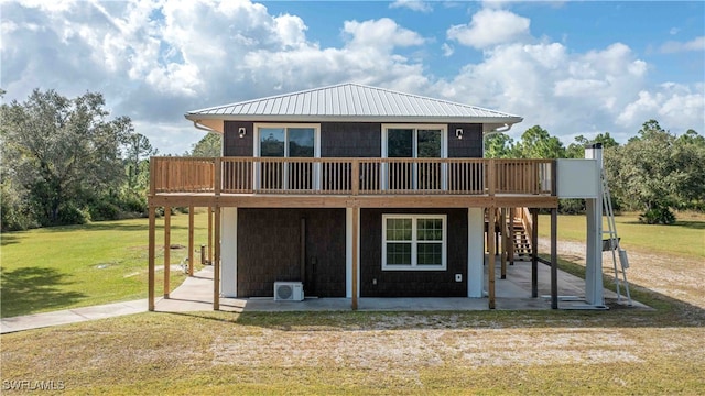 back of house featuring a wooden deck, a patio area, and a lawn