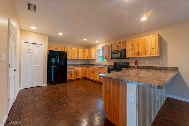 kitchen with sink, black appliances, dark hardwood / wood-style flooring, and kitchen peninsula