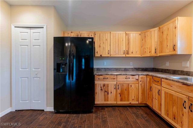 kitchen with sink, black refrigerator with ice dispenser, light brown cabinets, and dark hardwood / wood-style flooring