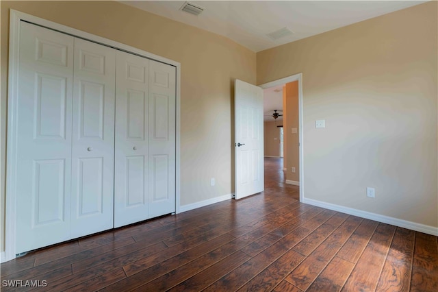 unfurnished bedroom with a closet and dark hardwood / wood-style flooring