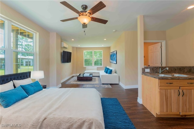 bedroom featuring multiple windows, sink, a wall mounted air conditioner, and dark hardwood / wood-style floors