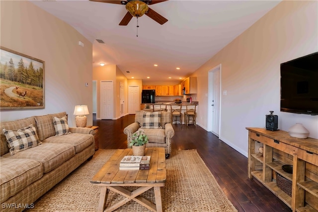 living room featuring ceiling fan and dark hardwood / wood-style flooring