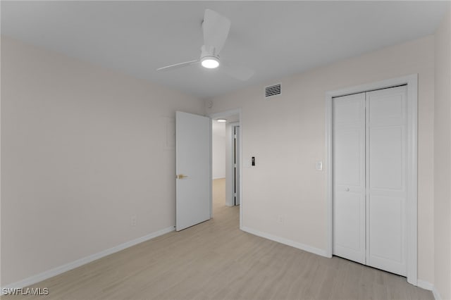 unfurnished bedroom with light hardwood / wood-style flooring, a closet, and ceiling fan