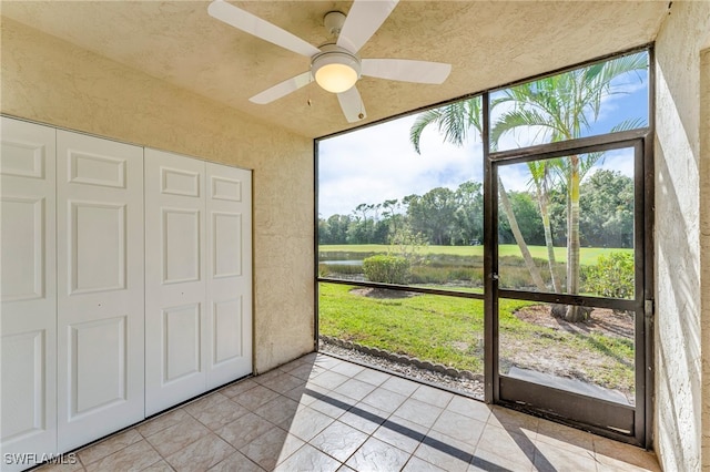 unfurnished sunroom featuring ceiling fan