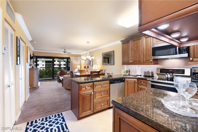 kitchen featuring stainless steel appliances, kitchen peninsula, hanging light fixtures, crown molding, and backsplash