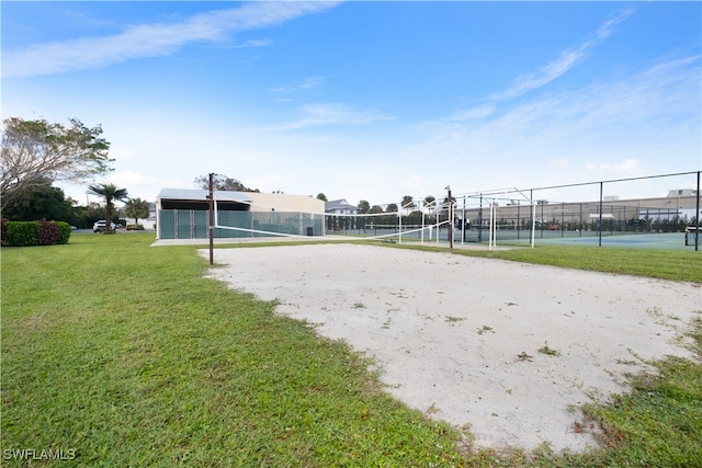 view of community with tennis court, a yard, and volleyball court