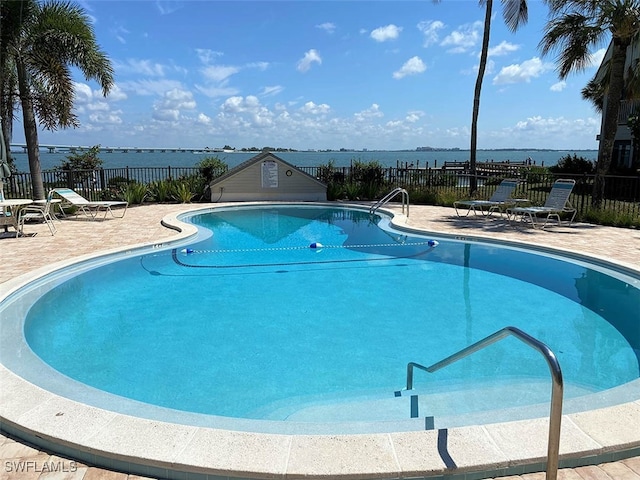 view of pool with a patio area and a water view