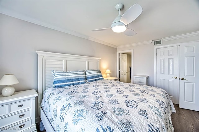 bedroom with ornamental molding, dark wood-type flooring, a closet, and ceiling fan