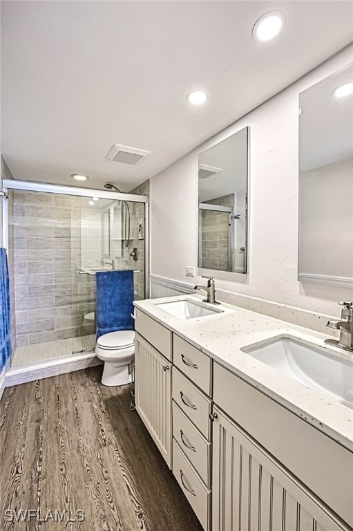 bathroom with vanity, hardwood / wood-style flooring, toilet, and an enclosed shower