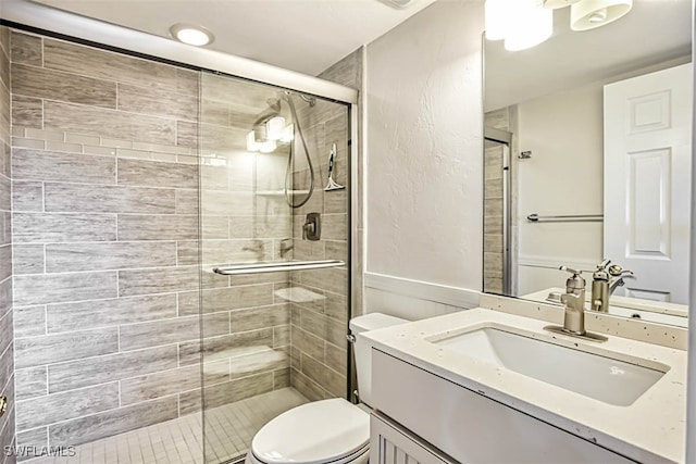 bathroom featuring vanity, toilet, and an enclosed shower