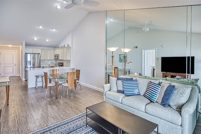 living room with ceiling fan, hardwood / wood-style flooring, and high vaulted ceiling