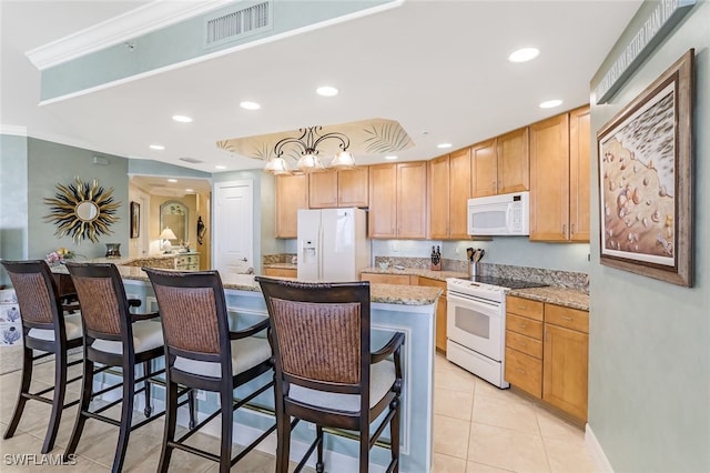 kitchen with light stone countertops, ornamental molding, a breakfast bar, white appliances, and a center island