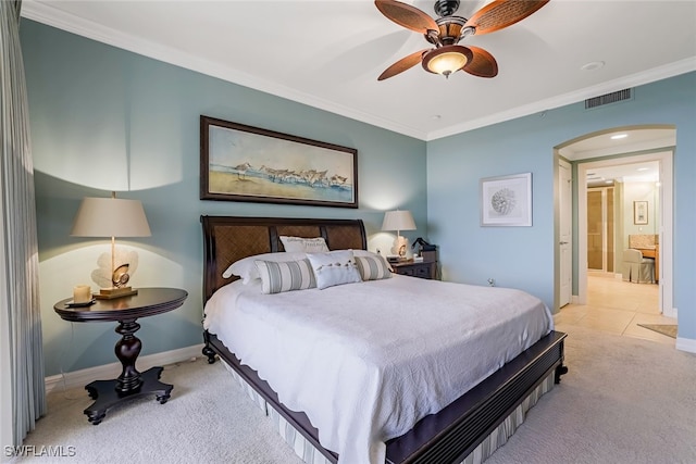 carpeted bedroom with ceiling fan, crown molding, and ensuite bathroom