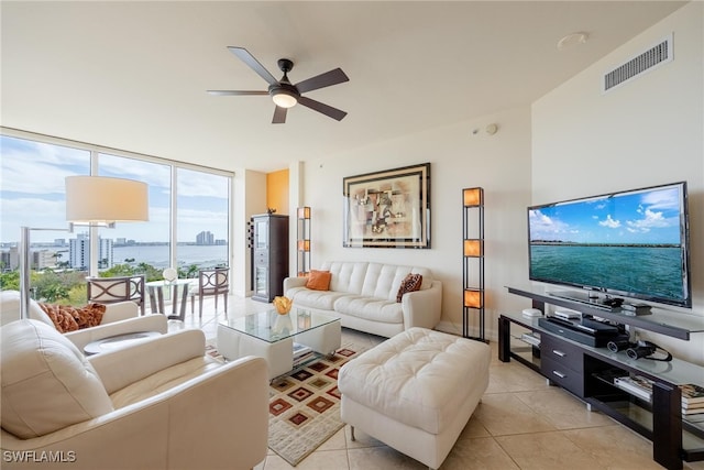 tiled living room with expansive windows and ceiling fan