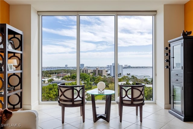 interior space with a water view, a wall of windows, and light tile patterned flooring