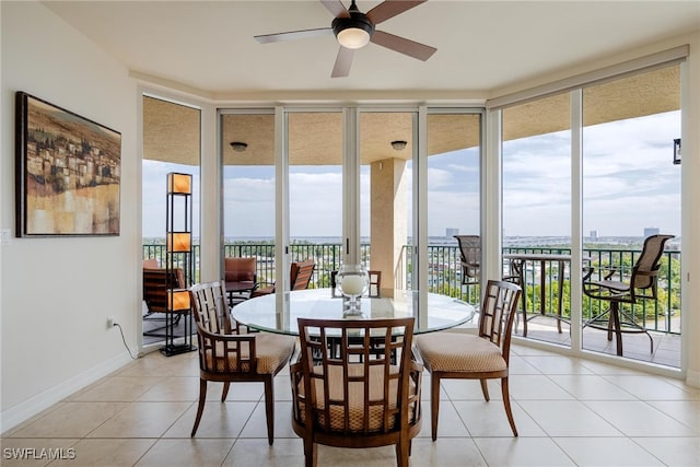 tiled dining room featuring expansive windows and ceiling fan