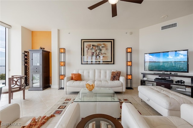 tiled living room with expansive windows and ceiling fan