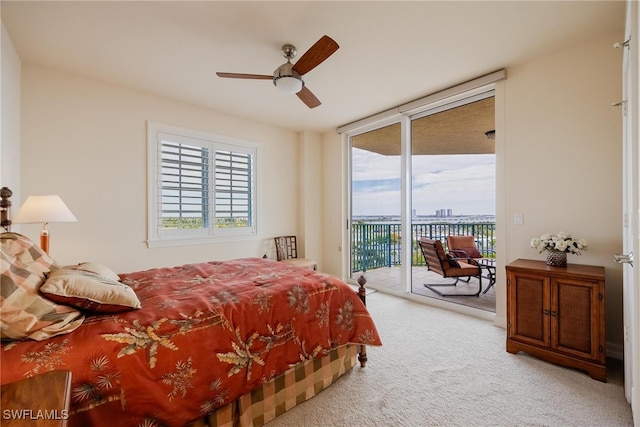 carpeted bedroom featuring ceiling fan, access to outside, and a wall of windows