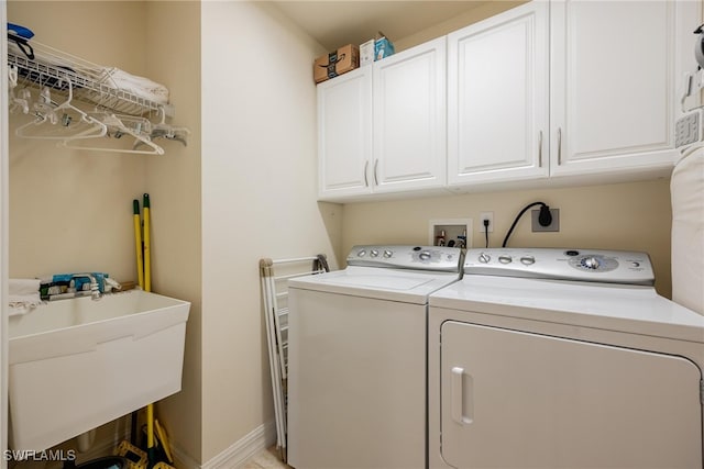 clothes washing area featuring cabinets, separate washer and dryer, and sink