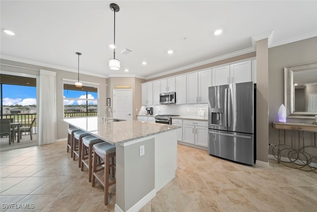 kitchen featuring appliances with stainless steel finishes, white cabinets, a kitchen island with sink, and sink