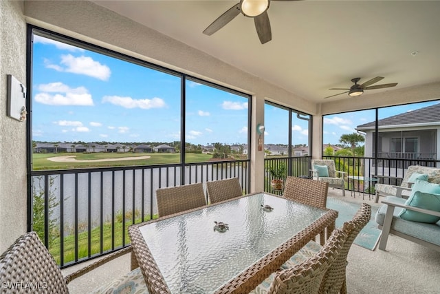 sunroom / solarium featuring a water view and ceiling fan