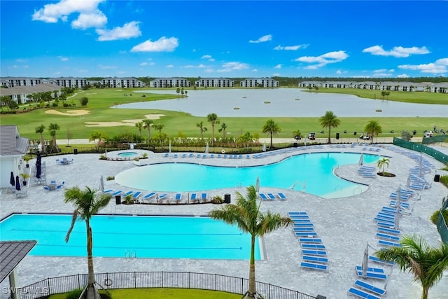 view of swimming pool featuring a patio, a water view, and a lawn