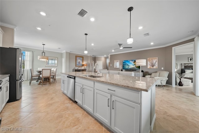 kitchen with white cabinets, an island with sink, appliances with stainless steel finishes, ornamental molding, and pendant lighting