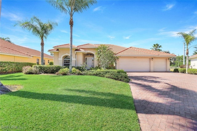 mediterranean / spanish house featuring a front lawn and a garage