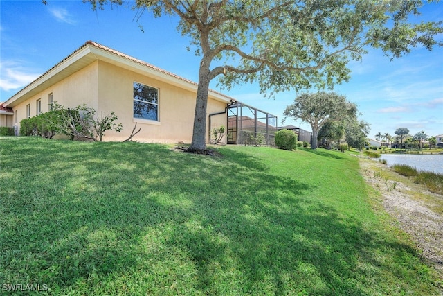 view of yard featuring a lanai and a water view