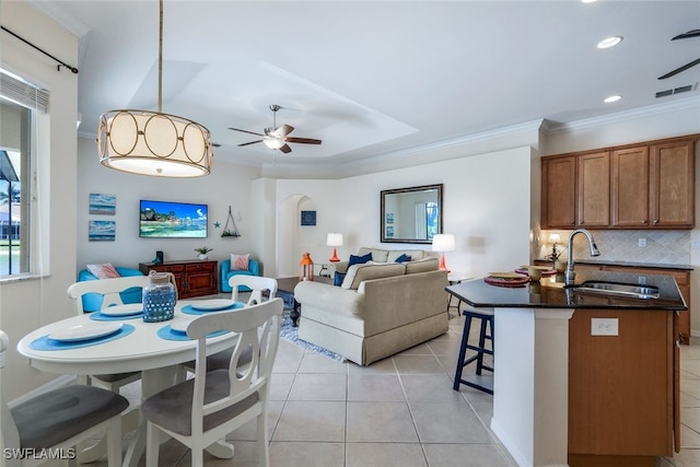 dining area featuring sink, light tile patterned flooring, crown molding, and ceiling fan