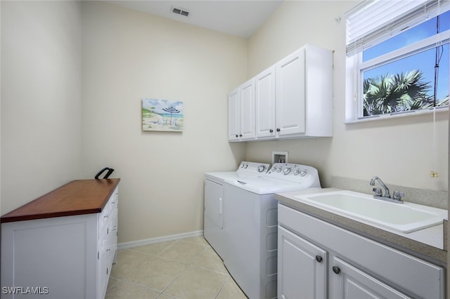 laundry room with cabinets, sink, washing machine and dryer, and light tile patterned floors