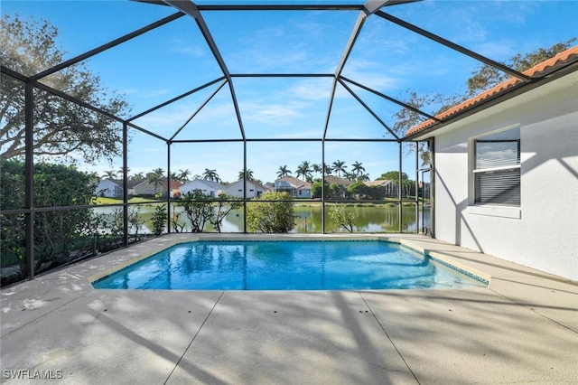 outdoor pool with a water view, a patio area, and glass enclosure