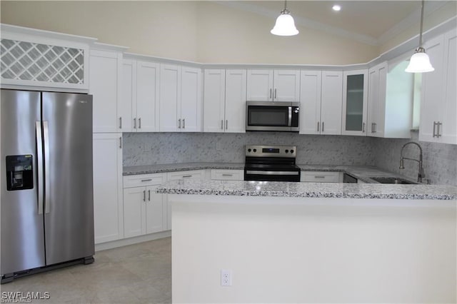 kitchen featuring lofted ceiling, stainless steel appliances, sink, decorative light fixtures, and white cabinetry