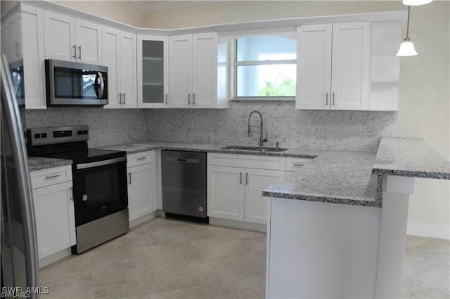 kitchen with appliances with stainless steel finishes, sink, kitchen peninsula, decorative light fixtures, and white cabinets