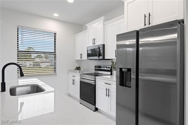 kitchen with sink, white cabinets, and stainless steel appliances