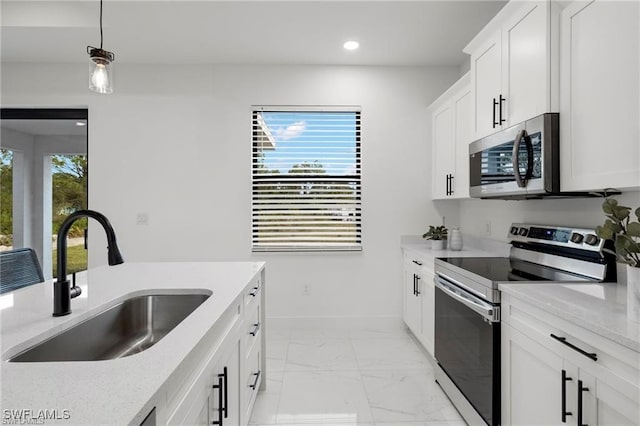 kitchen featuring a healthy amount of sunlight, stainless steel appliances, light stone countertops, and sink