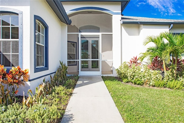 property entrance featuring a lawn