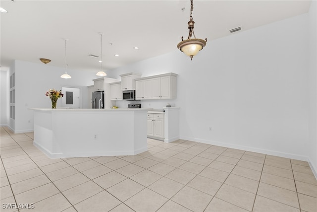 kitchen featuring hanging light fixtures, appliances with stainless steel finishes, a center island, and white cabinets