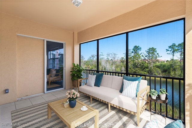 sunroom featuring a water view