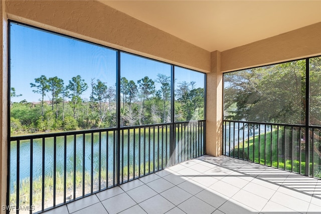 unfurnished sunroom featuring a water view