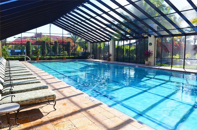 view of pool with a patio and glass enclosure