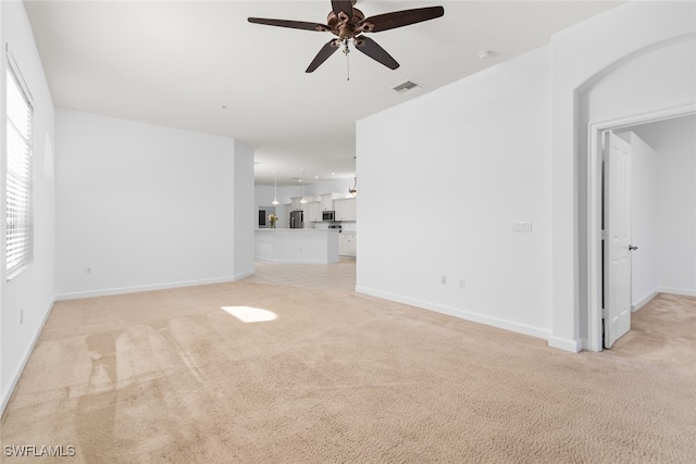 unfurnished living room featuring light carpet and ceiling fan