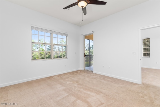 carpeted spare room featuring ceiling fan