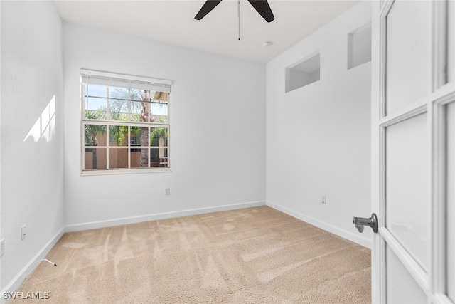 spare room featuring ceiling fan and light colored carpet