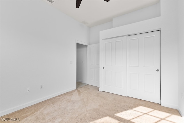 unfurnished bedroom with light colored carpet, a closet, and ceiling fan