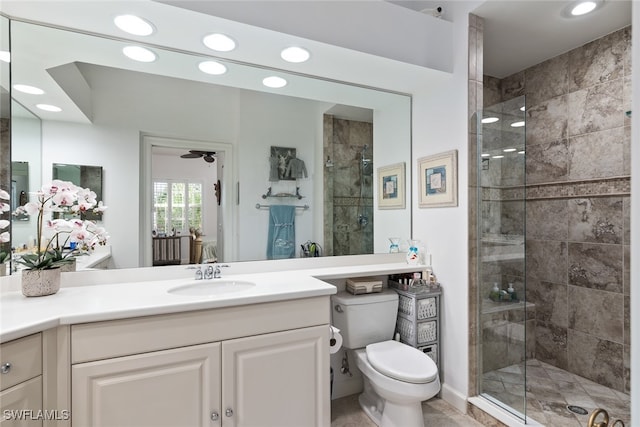 bathroom with vanity, toilet, an enclosed shower, and ceiling fan