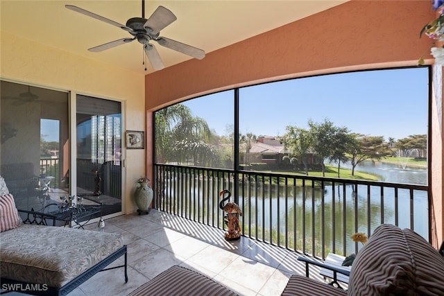 sunroom / solarium featuring a water view and ceiling fan