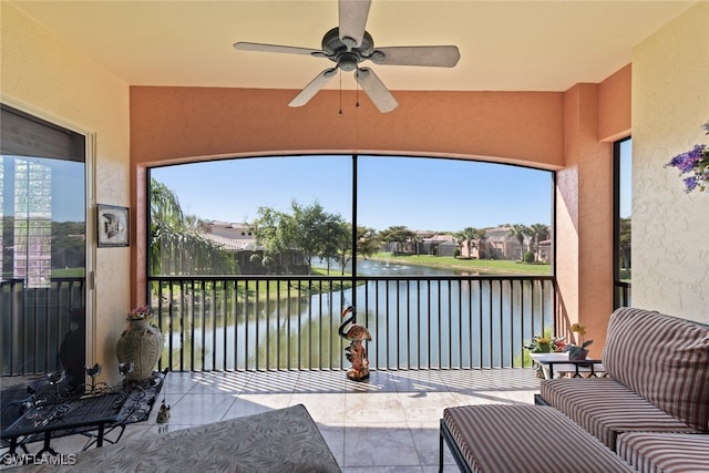 sunroom with a water view and ceiling fan