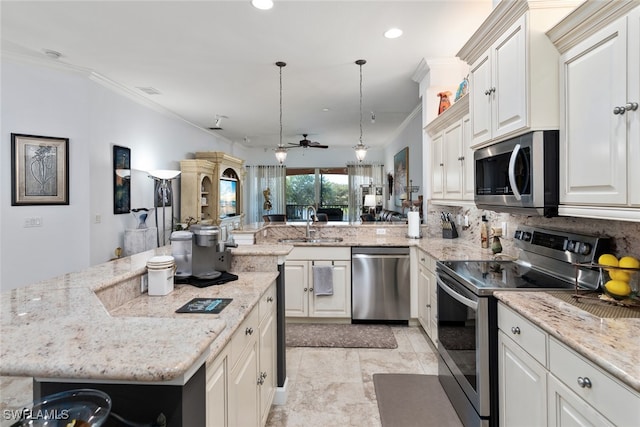 kitchen featuring a center island, ceiling fan, stainless steel appliances, pendant lighting, and crown molding